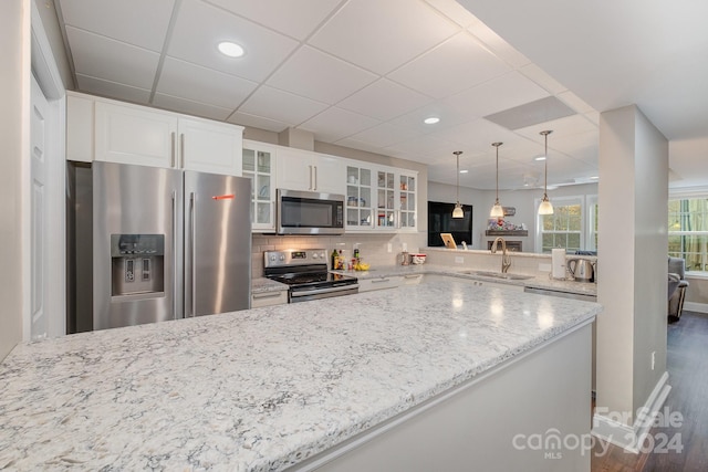 kitchen with white cabinetry, appliances with stainless steel finishes, sink, dark wood-type flooring, and kitchen peninsula