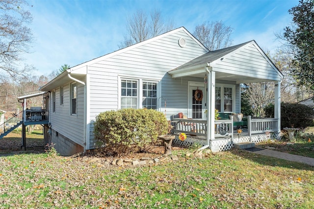 bungalow featuring covered porch and a front lawn