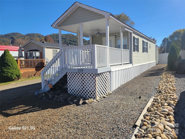 exterior space with a deck with mountain view and ceiling fan