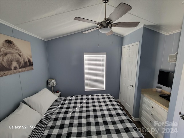 unfurnished bedroom with ornamental molding, vaulted ceiling, a closet, and ceiling fan