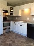 kitchen with dishwasher, exhaust hood, stainless steel stove, white refrigerator, and white cabinetry