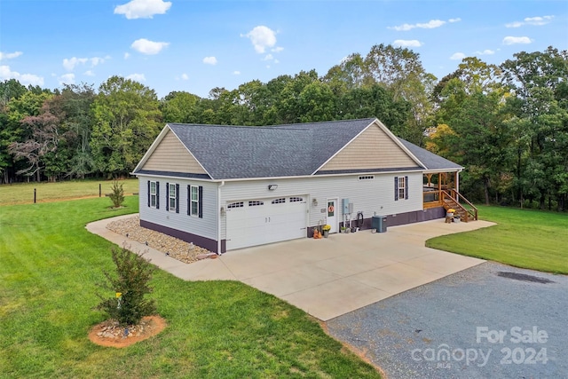 exterior space with central air condition unit, a front lawn, and a garage