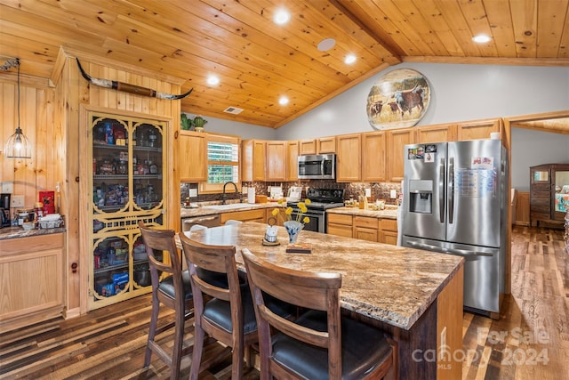 kitchen featuring appliances with stainless steel finishes, sink, vaulted ceiling with beams, a kitchen island, and dark hardwood / wood-style flooring