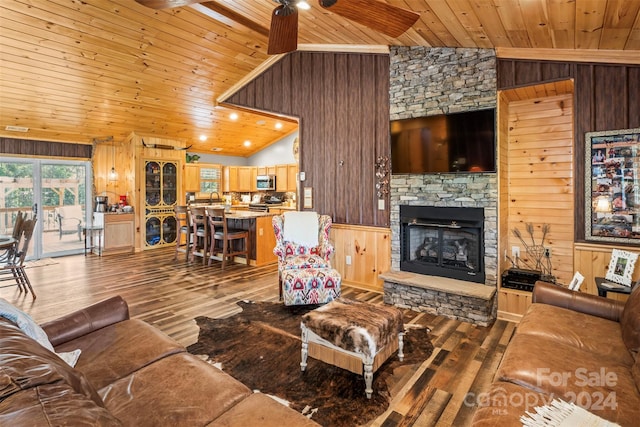 living room featuring lofted ceiling, wood ceiling, hardwood / wood-style flooring, wood walls, and a fireplace