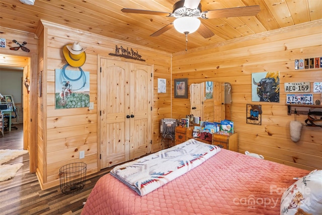 bedroom with wooden walls, wood ceiling, dark hardwood / wood-style floors, and ceiling fan