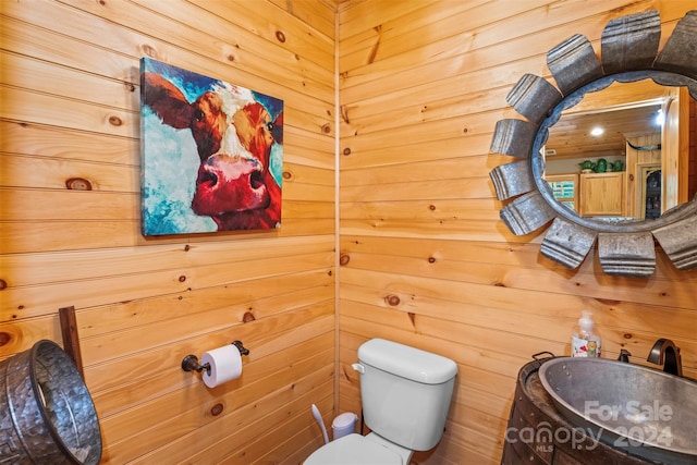 bathroom with wooden walls and toilet