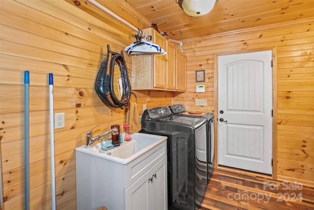 clothes washing area with washer and clothes dryer, wooden ceiling, wooden walls, dark wood-type flooring, and cabinets