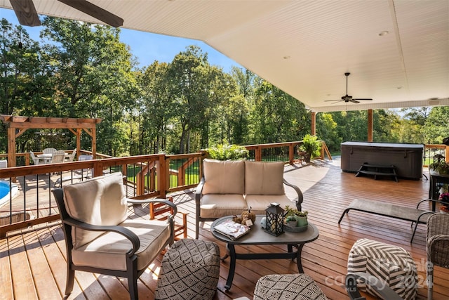 wooden terrace with ceiling fan, a hot tub, and an outdoor living space