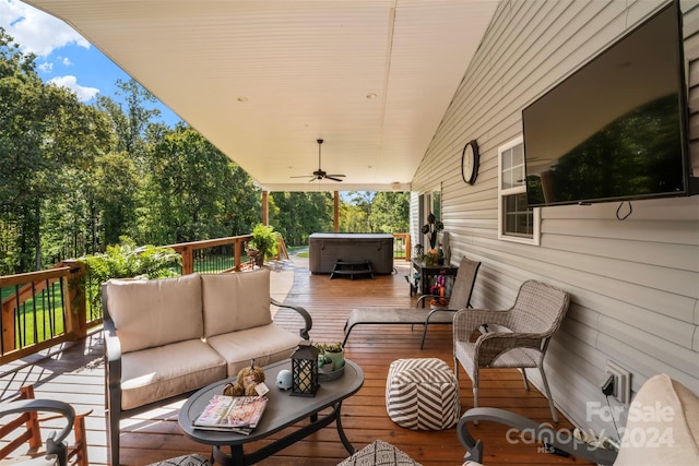 wooden terrace featuring a hot tub, an outdoor living space, and ceiling fan