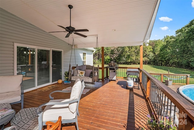 wooden terrace featuring a yard, a swimming pool, and ceiling fan