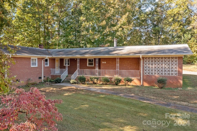 ranch-style house featuring covered porch and a front yard