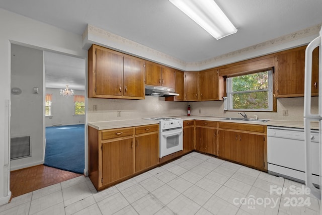 kitchen featuring light tile patterned flooring, a notable chandelier, sink, and white appliances