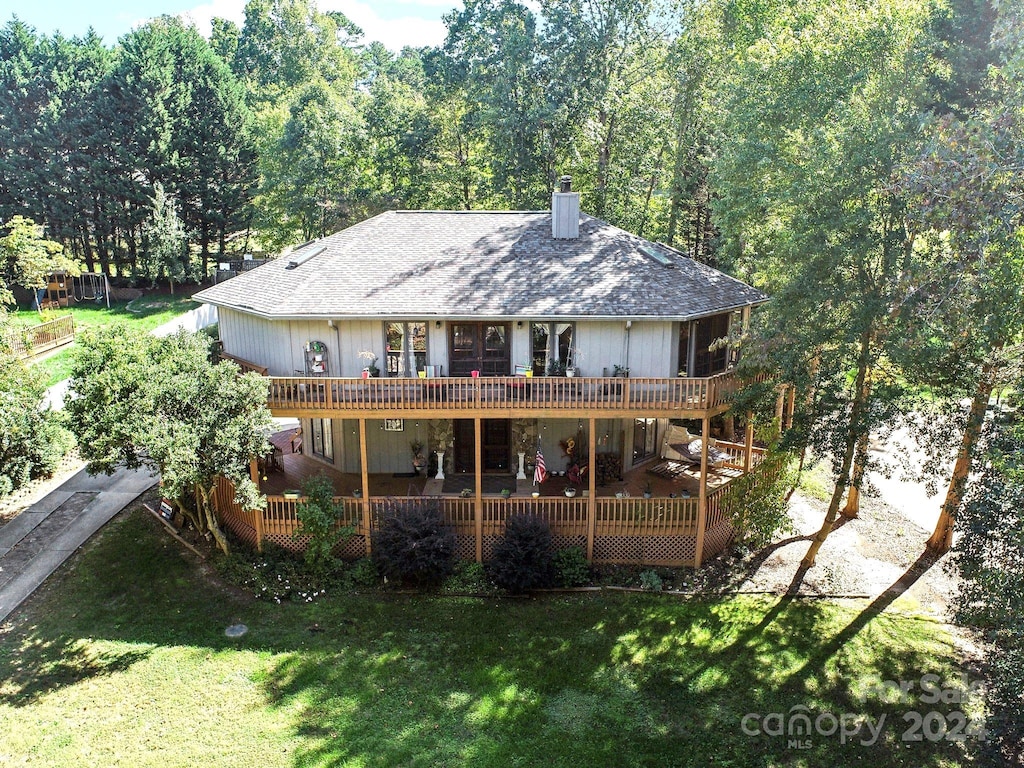 rear view of house with a yard and a wooden deck