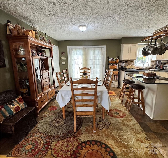 dining space with sink and a textured ceiling