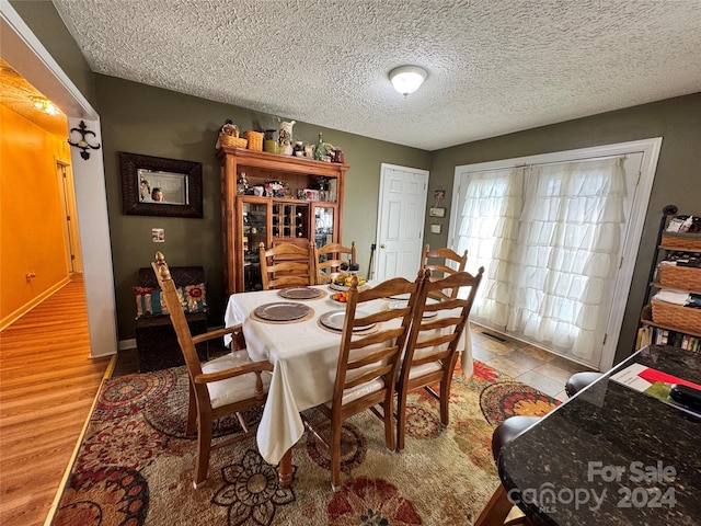 dining space with a textured ceiling and light wood-type flooring