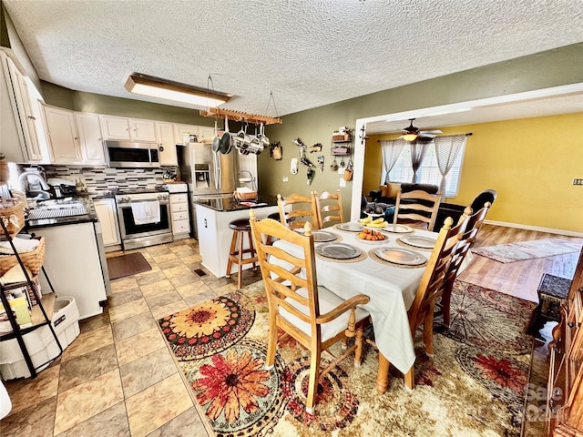 dining space with sink, a textured ceiling, and ceiling fan