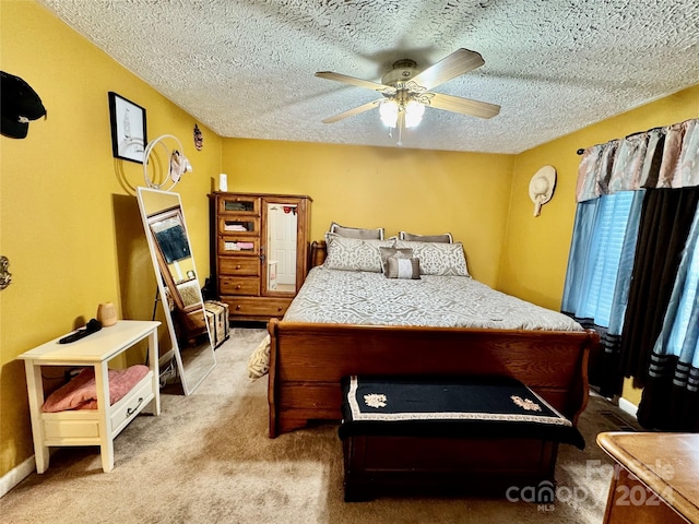 carpeted bedroom with a textured ceiling and ceiling fan