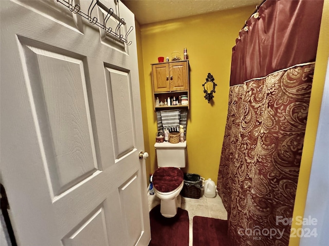 bathroom featuring toilet and tile patterned flooring