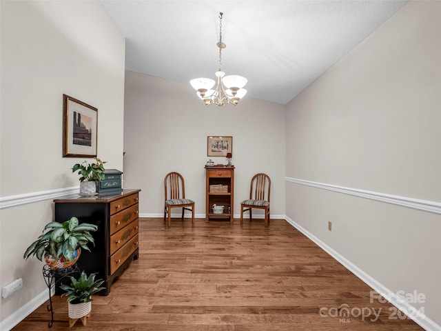 living area featuring a notable chandelier, hardwood / wood-style floors, and vaulted ceiling