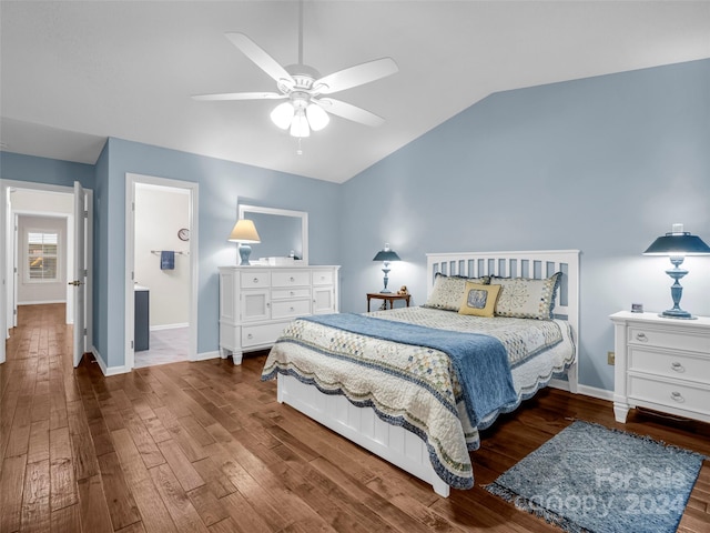 bedroom with dark wood-type flooring, ceiling fan, connected bathroom, and vaulted ceiling