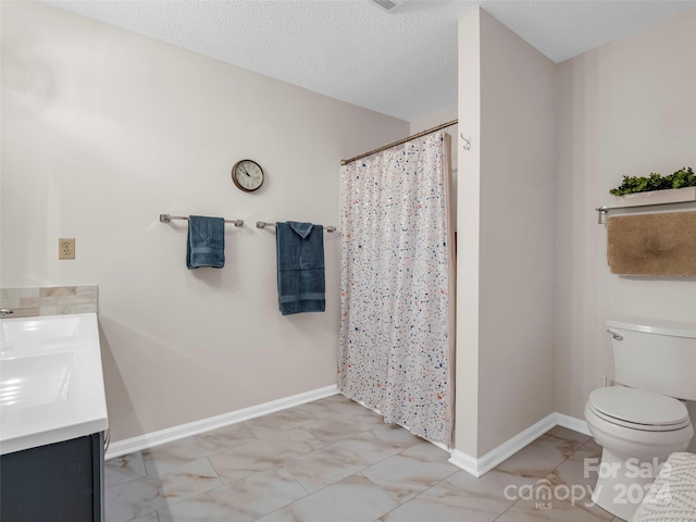 bathroom featuring vanity, toilet, and a textured ceiling