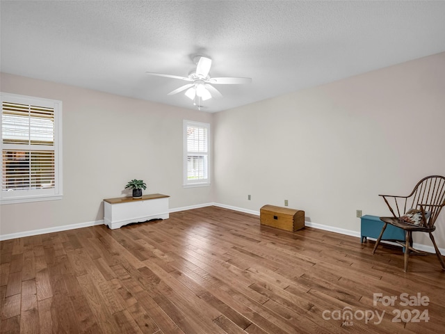 unfurnished room featuring hardwood / wood-style floors, a textured ceiling, and ceiling fan