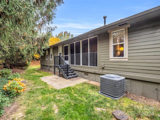 rear view of property with a yard and central AC unit