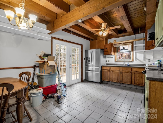 kitchen with stainless steel refrigerator with ice dispenser, pendant lighting, ceiling fan with notable chandelier, and light tile patterned floors