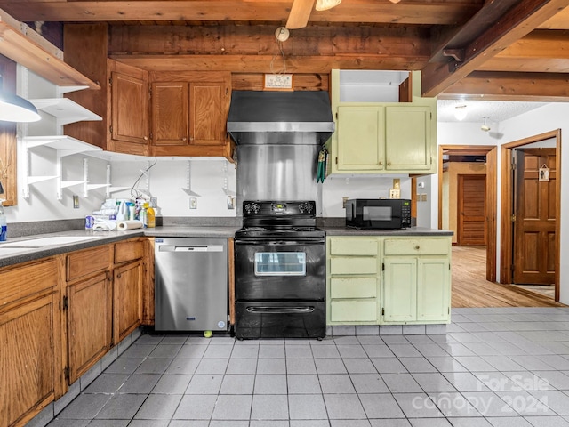 kitchen with beam ceiling, black appliances, light tile patterned flooring, and wall chimney exhaust hood