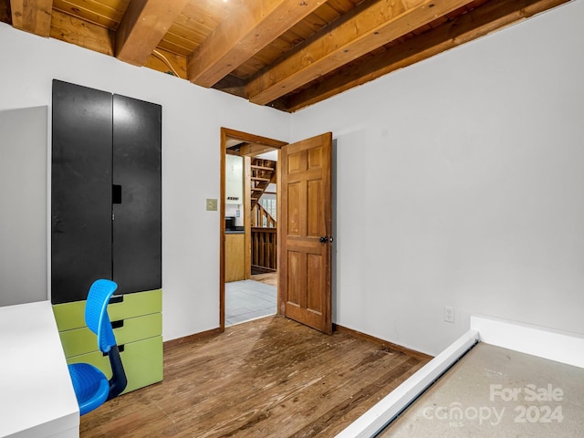 unfurnished bedroom with beam ceiling, wood ceiling, and hardwood / wood-style floors