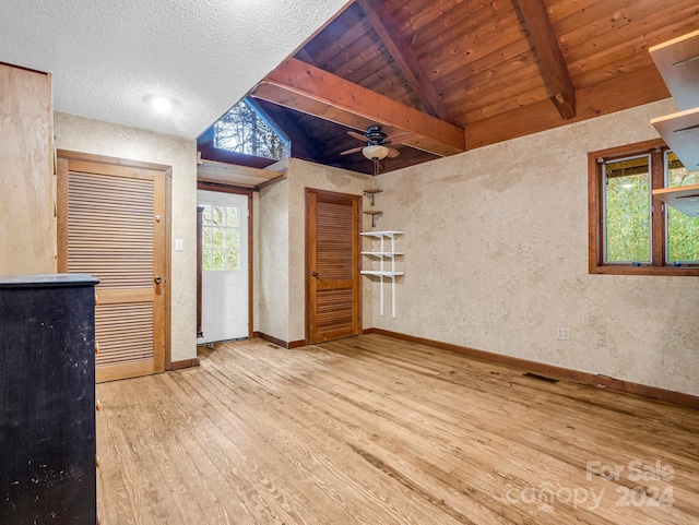 interior space with vaulted ceiling with beams, wood-type flooring, a healthy amount of sunlight, and ceiling fan