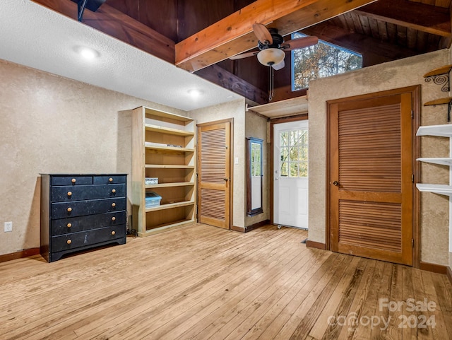 interior space featuring hardwood / wood-style floors, vaulted ceiling with beams, and ceiling fan