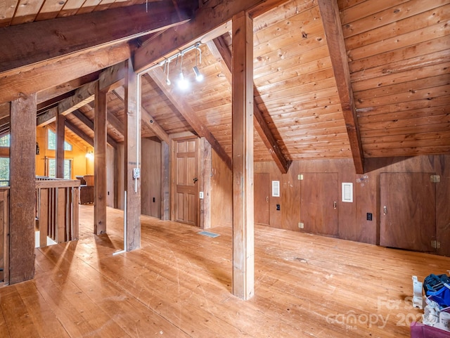 additional living space with vaulted ceiling with beams, hardwood / wood-style flooring, wooden ceiling, and wood walls