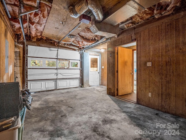 garage featuring wood walls and electric panel