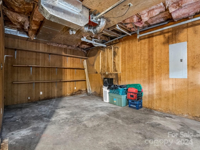 garage featuring electric panel and wooden walls