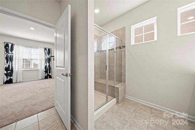 bathroom featuring a shower with door and tile patterned floors