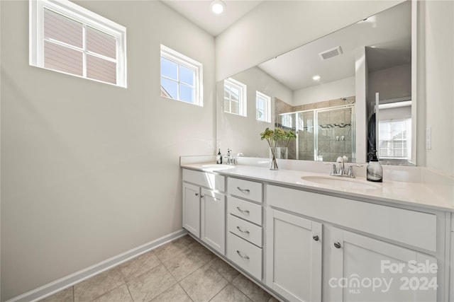 bathroom featuring vanity, tile patterned floors, and walk in shower