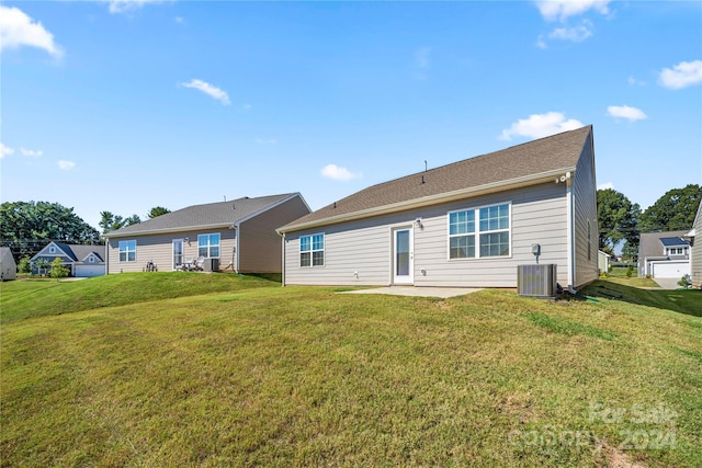 back of house with central AC unit and a lawn