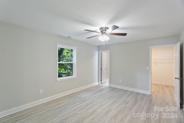545 Shamel Ct, Winston Salem, NC 27105 - unfurnished bedroom featuring light wood-style floors, baseboards, a walk in closet, ceiling fan, and a closet