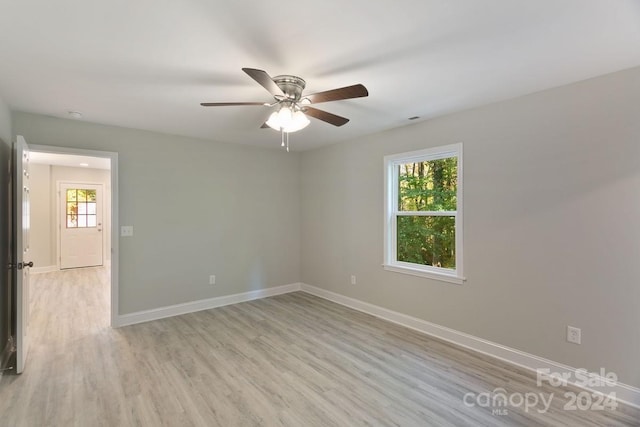 empty room with light hardwood / wood-style floors, plenty of natural light, and ceiling fan