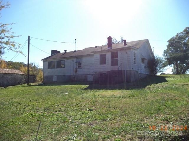 rear view of property featuring a yard