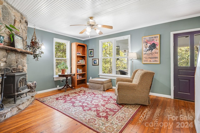 3942 Anderson Branch Rd, Marshall, NC 28753 - living area with wood-type flooring, ornamental molding, a ceiling fan, baseboards, and a wood stove