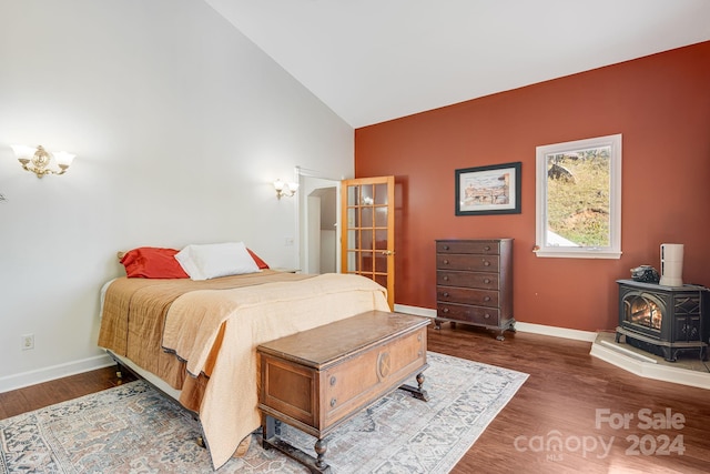 3942 Anderson Branch Rd, Marshall, NC 28753 - bedroom featuring a wood stove, baseboards, wood finished floors, and high vaulted ceiling