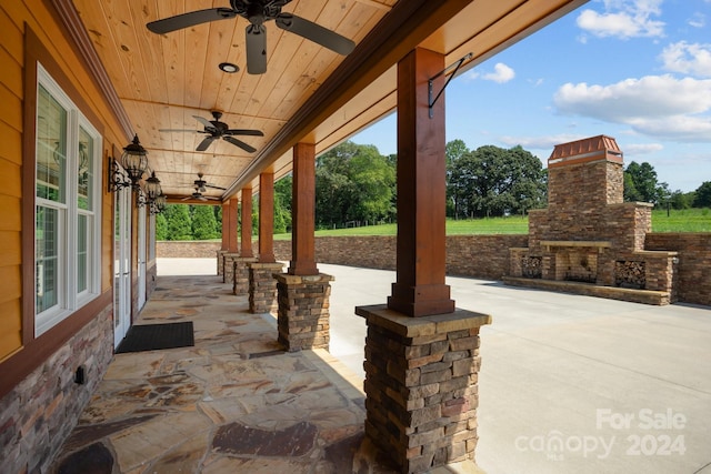 view of patio / terrace featuring ceiling fan and an outdoor stone fireplace