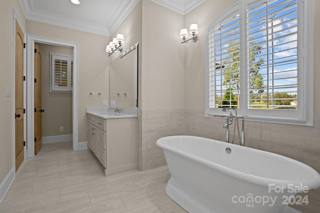 bathroom with tile walls, vanity, a tub, and crown molding