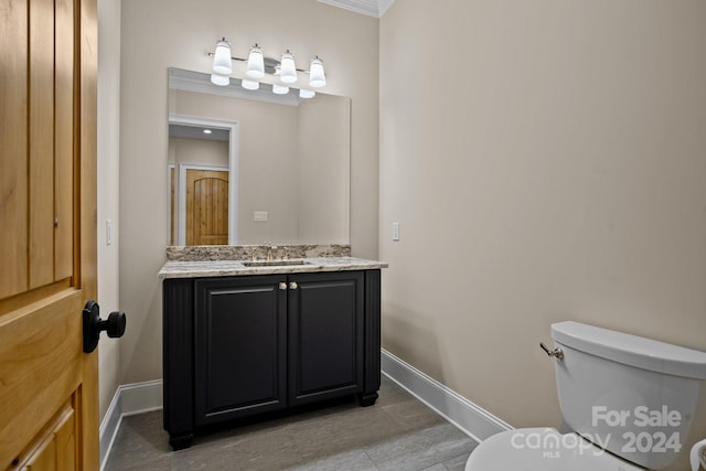 bathroom with vanity, toilet, and crown molding