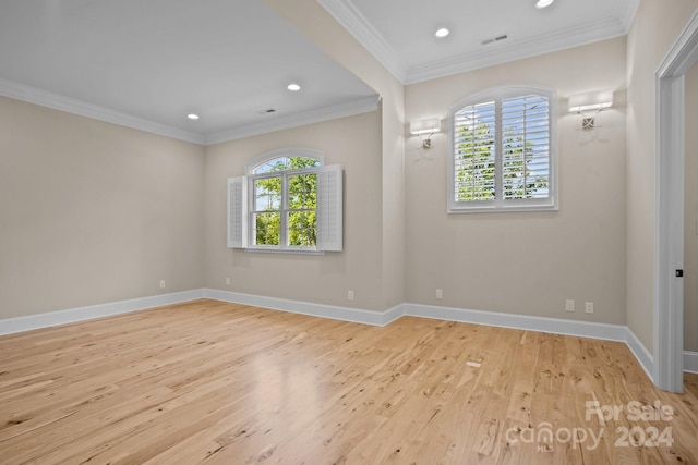 unfurnished room with ornamental molding, light wood-type flooring, and a wealth of natural light