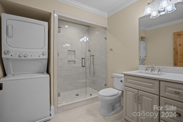 bathroom featuring walk in shower, stacked washer / drying machine, vanity, tile patterned floors, and toilet