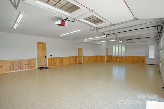 garage featuring wood walls and a garage door opener