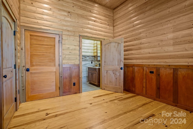 hallway with wooden walls and light hardwood / wood-style floors